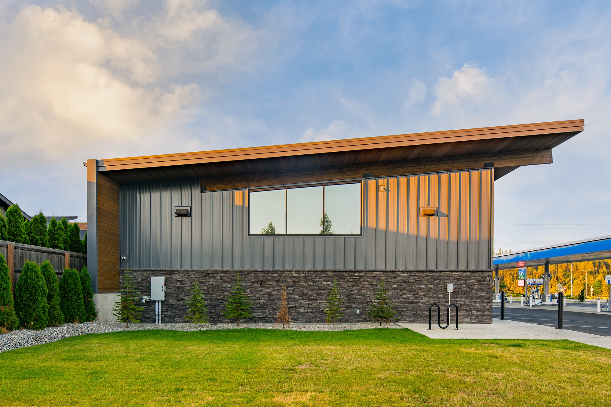 Detail of metal panel siding and stone base with tongue-and-groove wood soffit at Atlas Seltice Gas Station in CDA, Idaho
