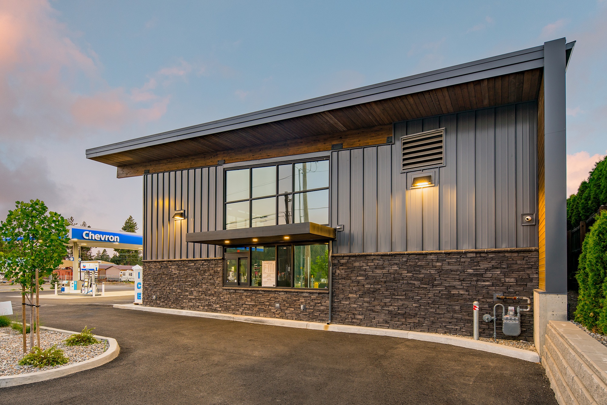 Side view of Atlas Seltice Gas Station drive-through window showing customer service lane, canopy cover, and modern exterior materials designed by Fusion Architecture
