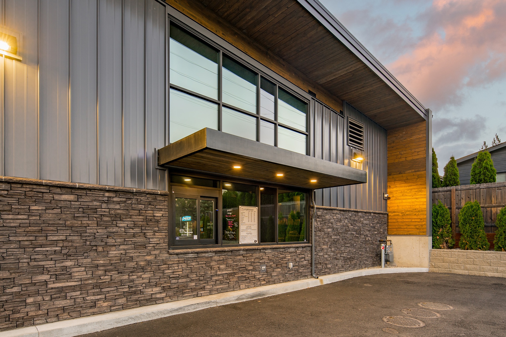 Drive-through window at Atlas Seltice Gas Station in Coeur d’Alene, Idaho with stone base, glass service window, and wood soffit detailing