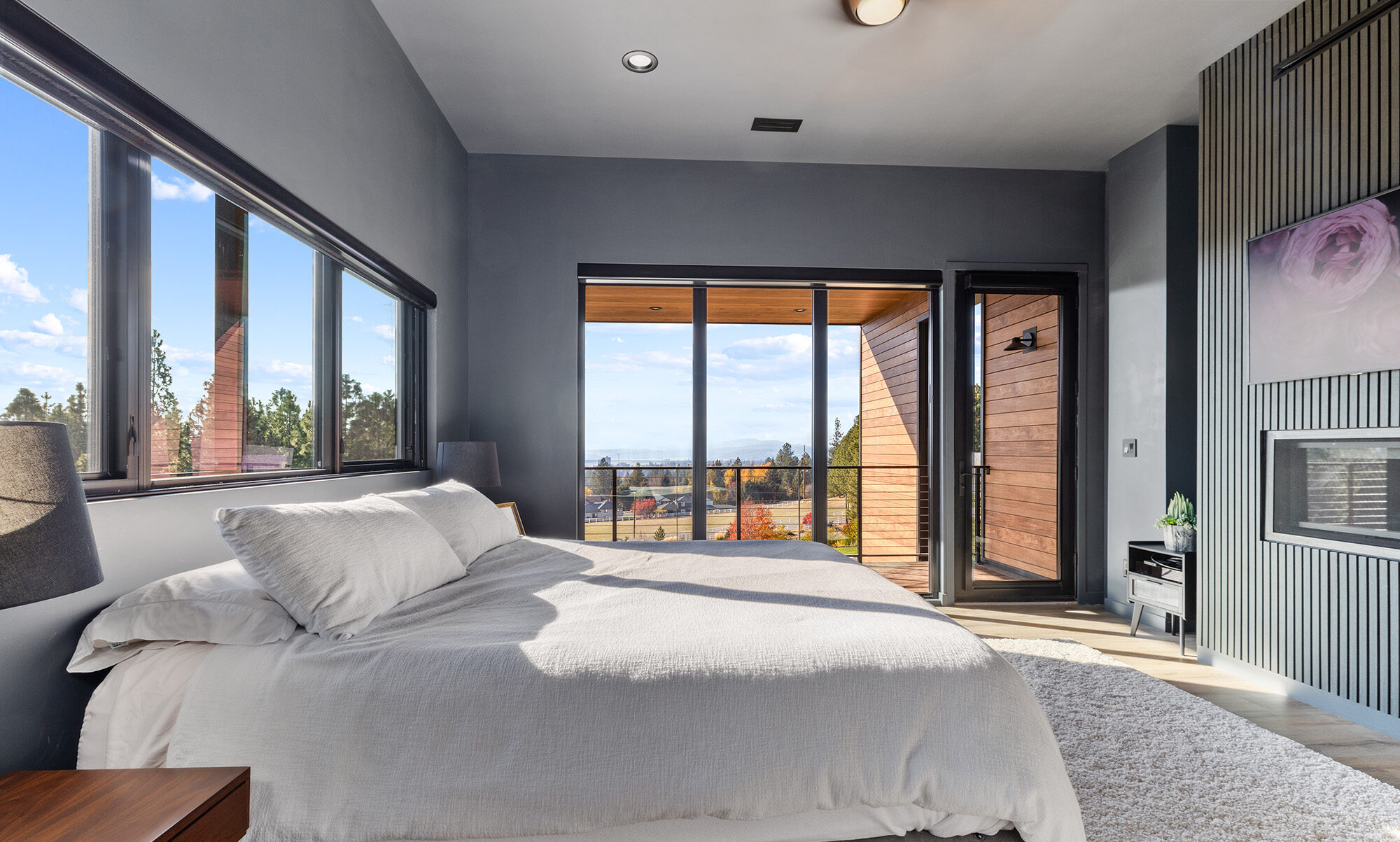 Primary bedroom at Fernan Hill Residence in Coeur d’Alene, Idaho featuring floor-to-ceiling windows, modern finishes, and views of the surrounding hillside