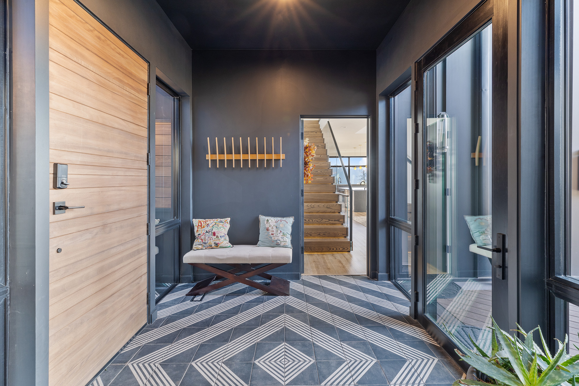 Entryway of Fernan Hill Residence in Coeur d’Alene, Idaho with covered approach, glass front door, and clean modern detailing