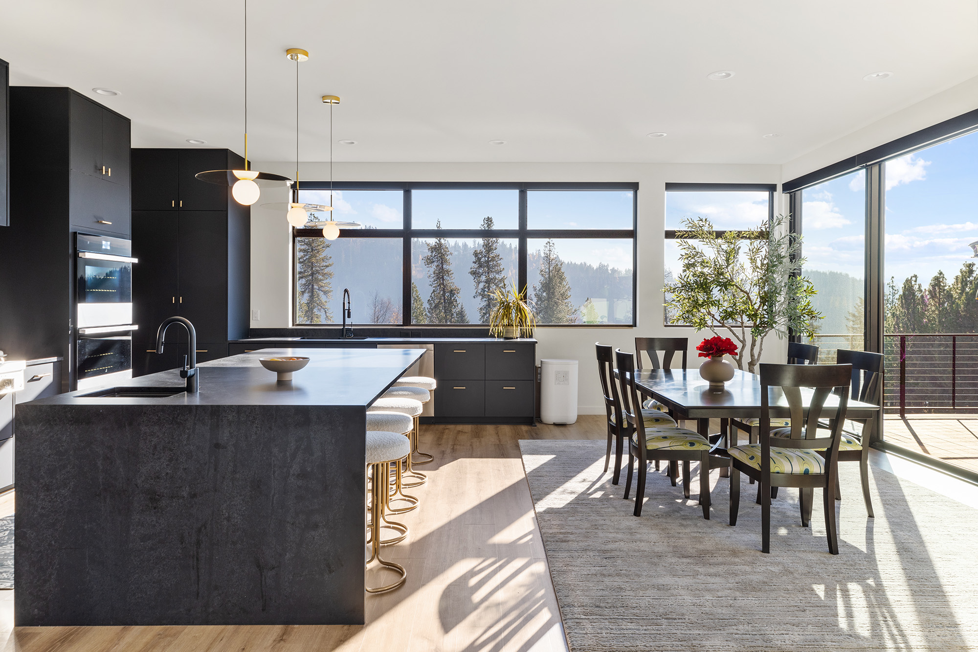 Open plan kitchen and living area at Fernan Hill Residence in CDA, Idaho, featuring wood cabinetry, central island, and natural light
