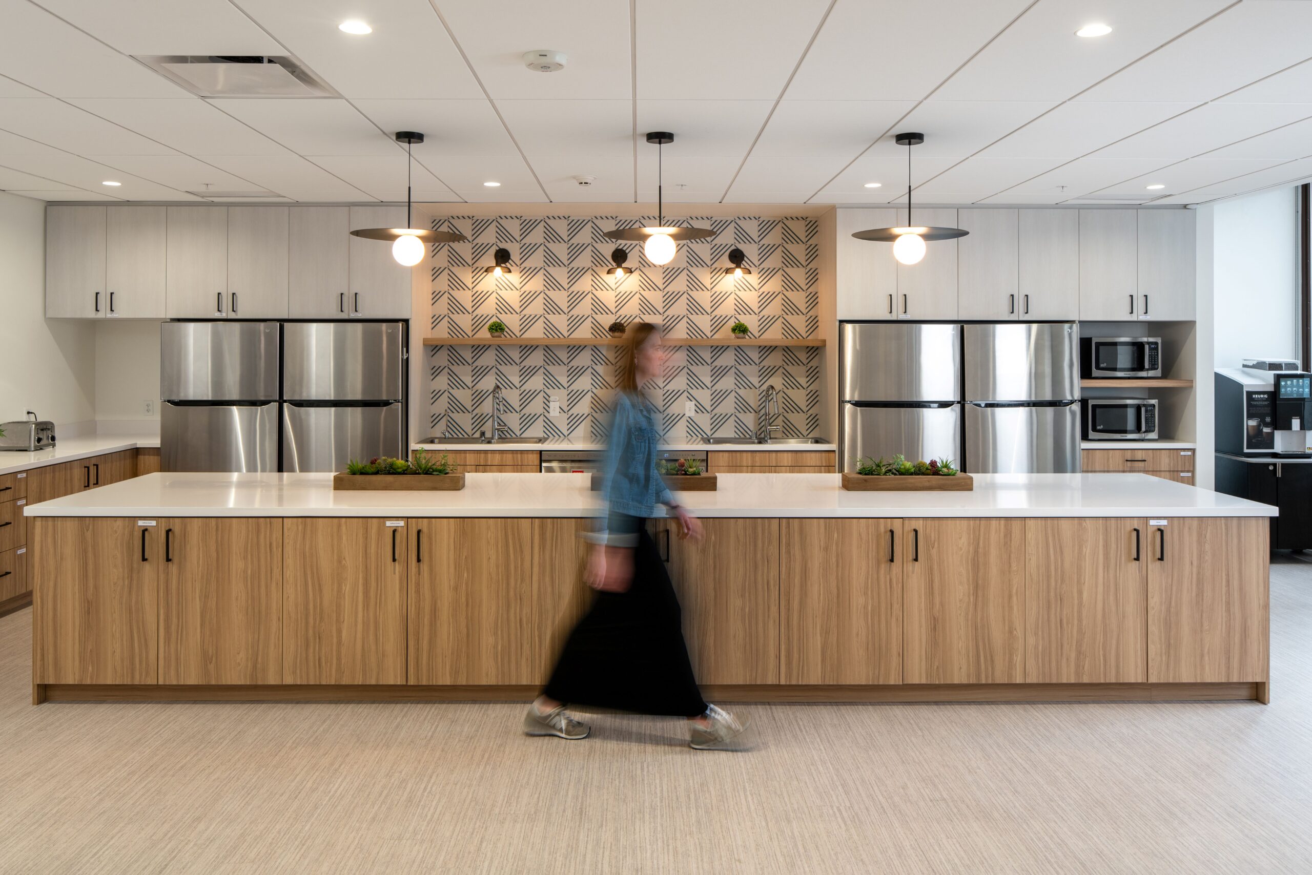 Kitchen area in the Coffman Engineering breakroom with modern cabinetry, stainless appliances, and seating